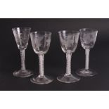 A set of three 18th Century wine glasses with ogee bowls engraved insects and flowers on white