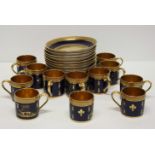 A set of twelve Limoges coffee cans and saucers decorated in gilt with leaves and heraldic animals