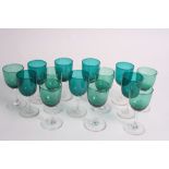 Fourteen wine glasses with green glass bowls on clear stems