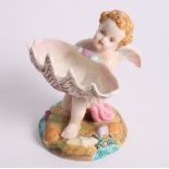 A Royal Worcester china sweetmeat dish in the form of a winged cherub holding a shell, 5" high,