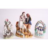 A 19th Century Staffordshire figure of lovers seated by a stream, 8 1/2" high, and two similar