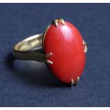A Chinese high carat gold dress ring set oval polished coral cabochon