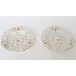 A pair of 19th Century Sèvres style china dinner plates decorated four floral cartouches on a