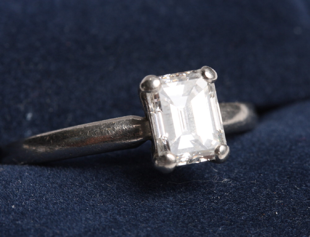 A platinum and diamond solitaire ring, the central emerald cut diamond weighing 1.28 carat, VVS2