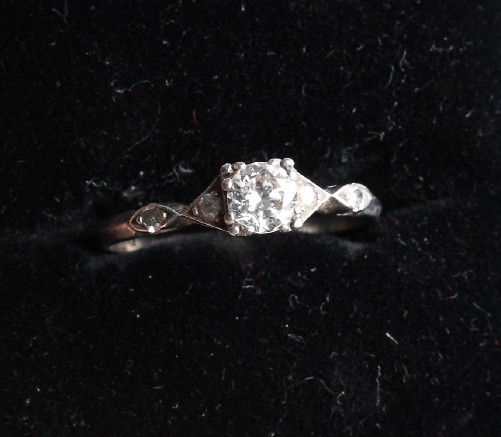 A platinum dress ring set central old cut diamond and two further diamonds to each shoulder