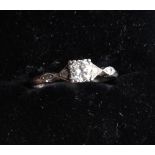 A platinum dress ring set central old cut diamond and two further diamonds to each shoulder