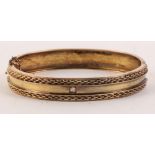 An Edwardian gold hinged bangle set single old cut diamond, 13.2g