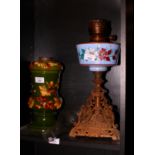A Bretby oil lamp base decorated flowers on a green ground and another early 20th Century oil lamp