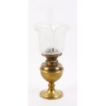 A brass oil lamp with etched shade and chimney