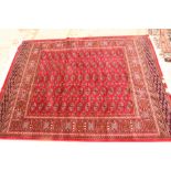 A Bokhara rug decorated five rows of guls on a red ground, 74" x 55" approx
