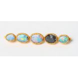 An Eastern high carat yellow gold and opal bar brooch (one stone missing)