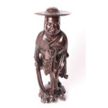 A Chinese carved hardwood figure of a monk holding prayer beads, 13" high