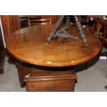 An oak oval tilt top dining table, on octagonal pillar and triangular platform base