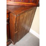 A rustic pine cupboard with boarded door enclosing two shelves, 23" wide