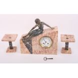 An Art Deco clock garniture comprising pink and black marble cased mantel clock in wedge-shaped case