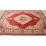 A Kum design carpet decorated floral design on a red and ivory ground, 110" x 78" approx