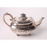 A silver melon-shaped teapot with half fluted body and ebonised knop, 16.9oz troy approx