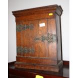 An oak wall mounted cabinet with decorative stamped metal furniture, 14" wide