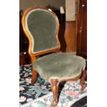 A Victorian mahogany framed nursing chair, upholstered in a green velour, on cabriole supports
