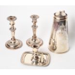 An Arts & Crafts style silver plated hot water jug, a pair of plated candlesticks and a plated
