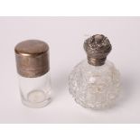 A glass smelling salts bottle with silver cap and a cut glass scent bomb with embossed silver cap