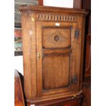 An oak wall hung corner cupboard enclosed panel door carved central rosette and lozenge, 28" wide