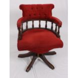 A Captain's chair with spindles to back, upholstered in red, on swivel base
