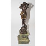 An Art Nouveau bronzed and gilded spelted statue of a lady diver, on green onyx base, 18" high