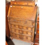 A 17th Century design oak bureau with fitted interior over four long graduated drawers, on bun