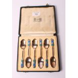 A set of six Liberty & Co silver grapefruit spoons with Art Nouveau stylised floral and enamelled