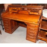 An oak roll top desk, fitted drawers and pigeonholes, on block base, 60" wide