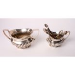 A silver two-handled sugar bowl with half fluted decoration and a matching milk jug, 12.8oz troy