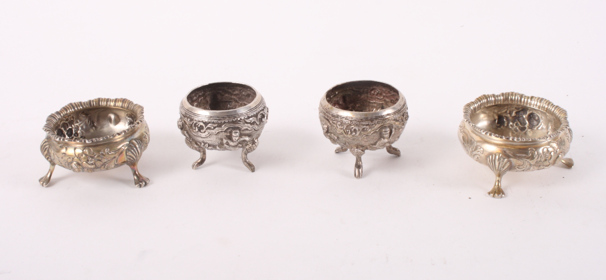A pair of late 19th Century circular silver cauldron salts embossed flowers on three feet, 3.2oz