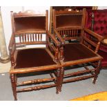 A pair of late 19th Century walnut spindle back elbow chairs with padded seats, on turned and