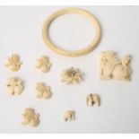 A turned ivory bangle, a carved ivory button and buckle set and two carved ivory elephant charms