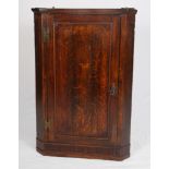 A Georgian oak and mahogany inlaid corner cupboard, the interior fitted shaped shelves enclosed