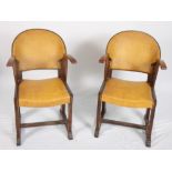 A pair of early 20th Century oak armchairs, upholstered in a brown nailed leatherette