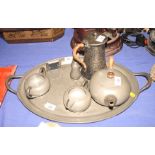 A Liberty's "Tudric" pewter three-piece teaset with matching tray, a pair of similar condiments, a