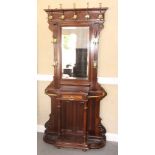 A late 19th Century carved walnut hall stand, fitted nine hooks, central mirror, marble top glovebox