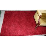 A red textured pile rug, 72" x 48" approx