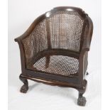 A child's carved walnut double bergère tub shape easy armchair, on hairy paw feet