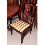A set of four mahogany vertical rail back dining chairs with drop-in seats