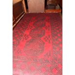 An Afghan rug decorated four octagonal guls on a red ground with four geometric border stripes,