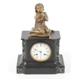 A Victorian mantel clock in black slate case with gilt metal surmount of a praying child