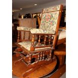 An American walnut framed rocking elbow chair, upholstered in a floral fabric