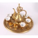 A Turkish gilt metal coffee pot with matching circular tray, a sugar bowl and six tots