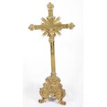 A brass crucifix on triangular scrolled base, 38" high