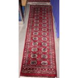 A Bokhara runner of traditional design on a plum ground, 74" x 22" approx