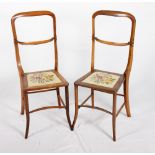 A pair of late 19th Century rosewood "deportment" chairs with drop-in tapestry panel seats, on
