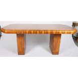 An Art Deco figured walnut octagonal dining table raised on two plinths, 74" long